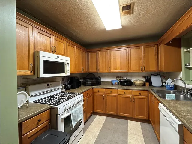 a kitchen with stainless steel appliances a stove sink microwave and cabinets