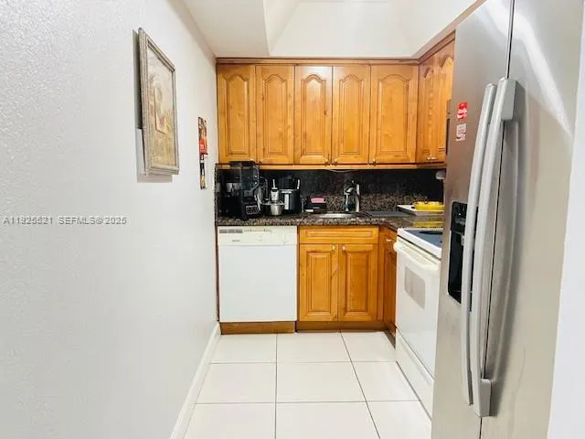 a kitchen with a refrigerator a sink and cabinets