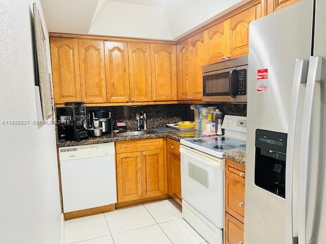 17530 Northwest 68th Avenue, Unit C2007 Hialeah, FL 33015 - Photo 5 of 18 a kitchen with stainless steel appliances granite countertop a refrigerator stove top oven and sink