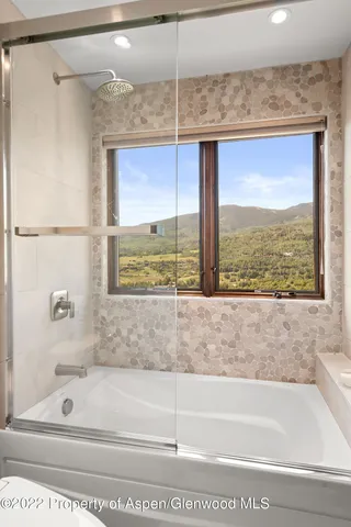 a bathroom with a tub sink and mirror