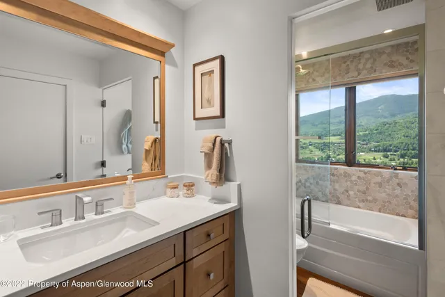 a bedroom with a bed and large windows