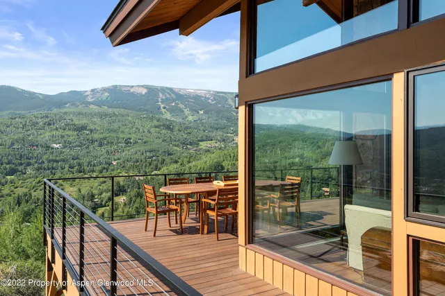 a view of a patio with table and chairs with wooden floor and fence