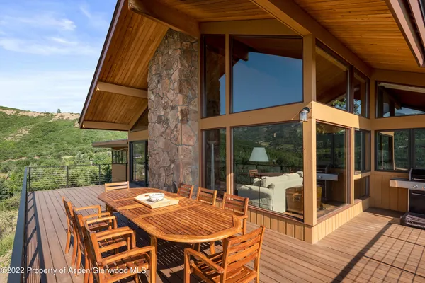 a view of a roof deck with table and chairs