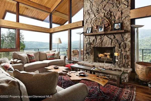 a living room with patio furniture and a floor to ceiling window