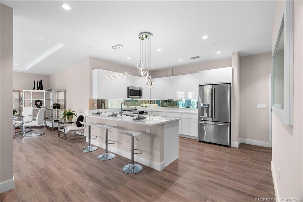 Undisclosed Address Stuart, FL 34994 - Photo 16 of 58 a kitchen with stainless steel appliances kitchen island hardwood floor sink and stove