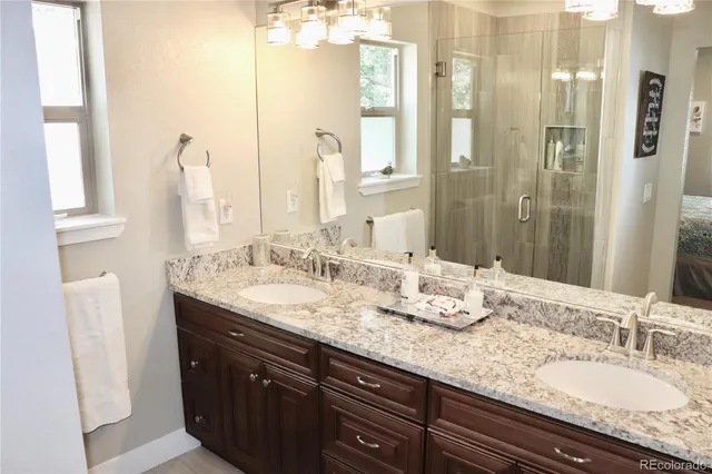a bathroom with double vanity sinks and a mirror