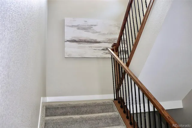 a view of staircase with railing and white walls