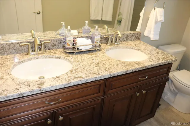 a bathroom with a granite countertop sink toilet and shower