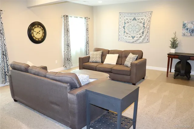 a living room with furniture and a wall painting