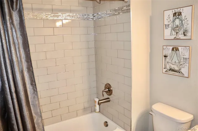 a large bed sitting in a bedroom next to a window and a chandelier