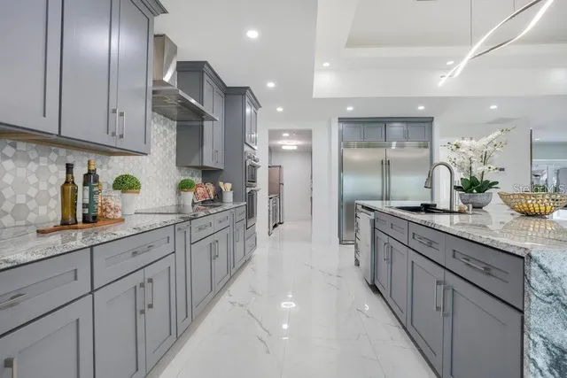 a large kitchen with stainless steel appliances lots of counter space sink and a refrigerator
