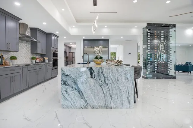 a kitchen with stainless steel appliances granite countertop a sink a stove and a wooden floors