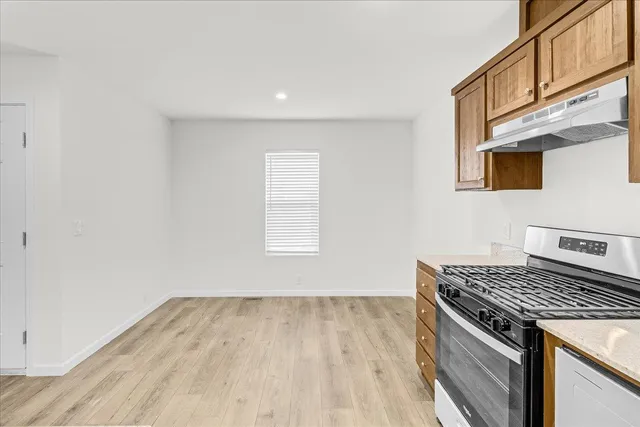 a kitchen with granite countertop a sink cabinets and stainless steel appliances
