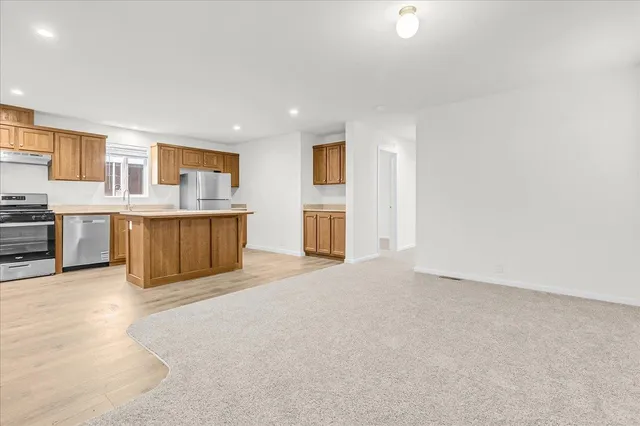 a kitchen with stainless steel appliances a stove and white cabinets