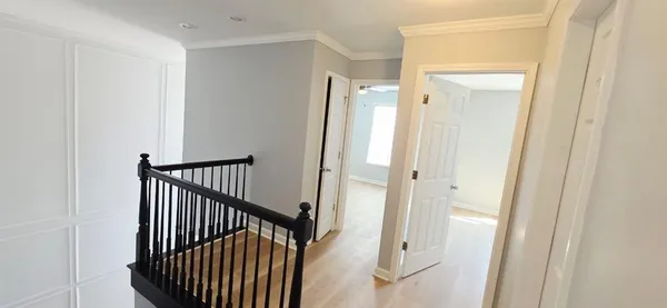 a view of a hallway with wooden floor and staircase