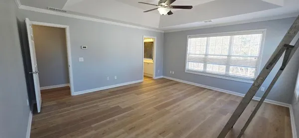 an empty room with wooden floor and windows