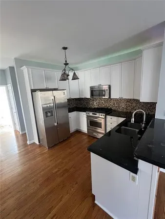 a kitchen with granite countertop a refrigerator and a sink