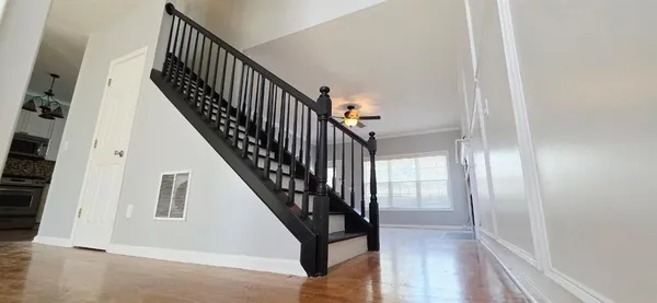 a view of staircase with wooden floor and a rug