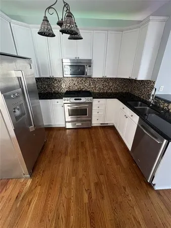 a kitchen with granite countertop a stove and cabinets