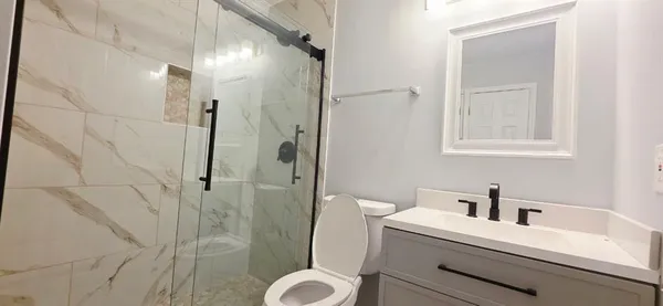 a bathroom with a sink a toilet and shower