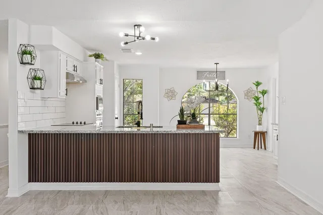 a kitchen with stainless steel appliances granite countertop a stove a sink and a microwave