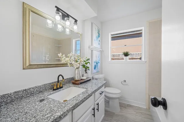 an empty room with wooden floor and ceiling fan