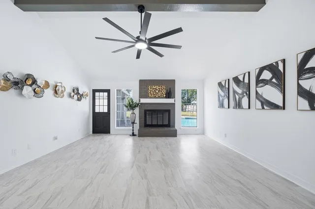 a view of an empty room with a fireplace and a window