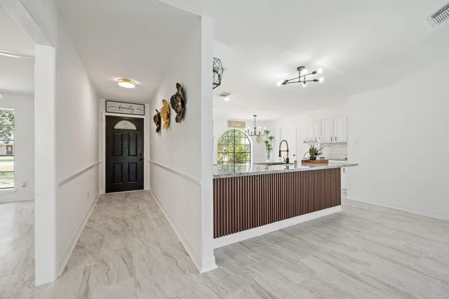 a kitchen with granite countertop a sink cabinets and wooden floor