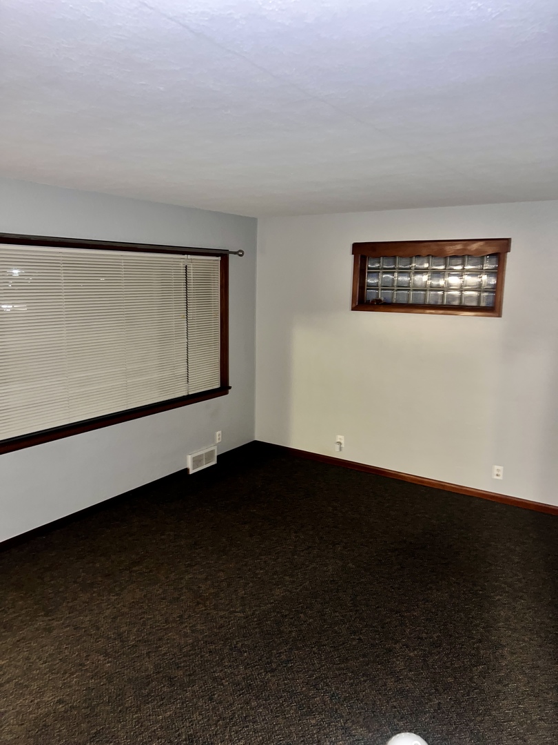 1160 West Marion Street Joliet, IL 60436 - Photo 2 of 7 a view of an empty room with wooden floor and a window