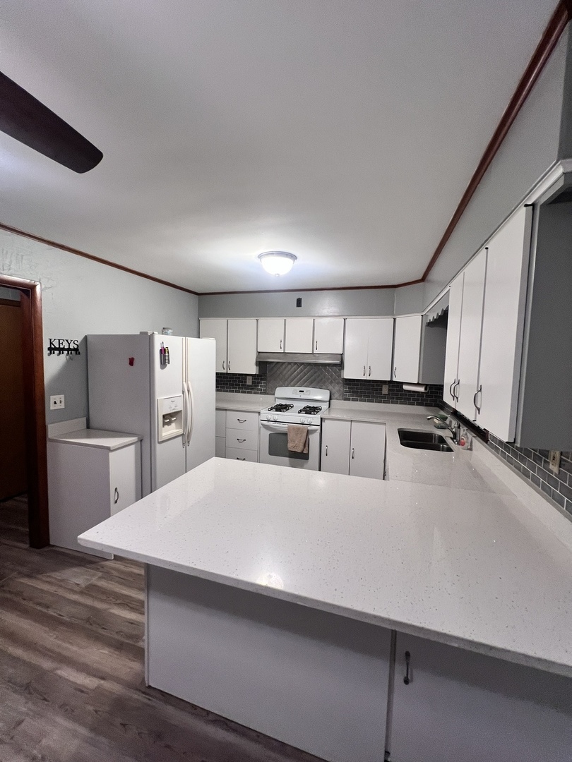 1160 West Marion Street Joliet, IL 60436 - Photo 3 of 7 a large white kitchen with a refrigerator a stove and a sink