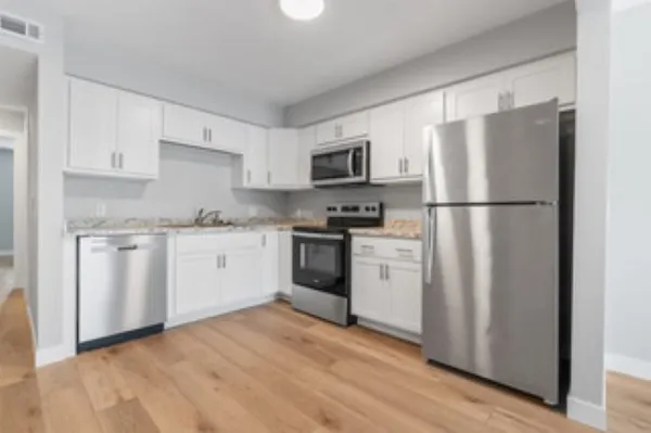 a kitchen with a refrigerator stove and white cabinets