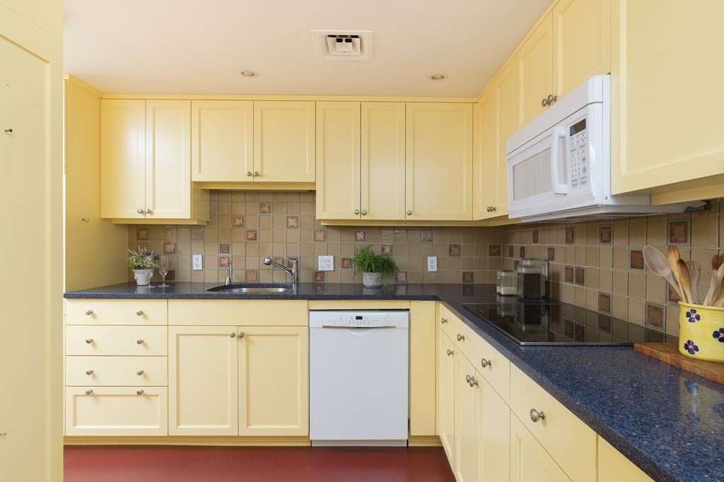 130 Mt Auburn Street, Unit 310 Cambridge, MA 02138 - Photo 17 of 21 a kitchen with granite countertop white cabinets and white appliances