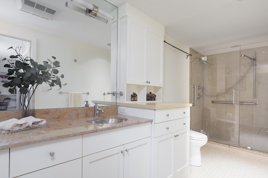 130 Mt Auburn Street, Unit 310 Cambridge, MA 02138 - Photo 8 of 21 a bathroom with a granite countertop sink a toilet and shower