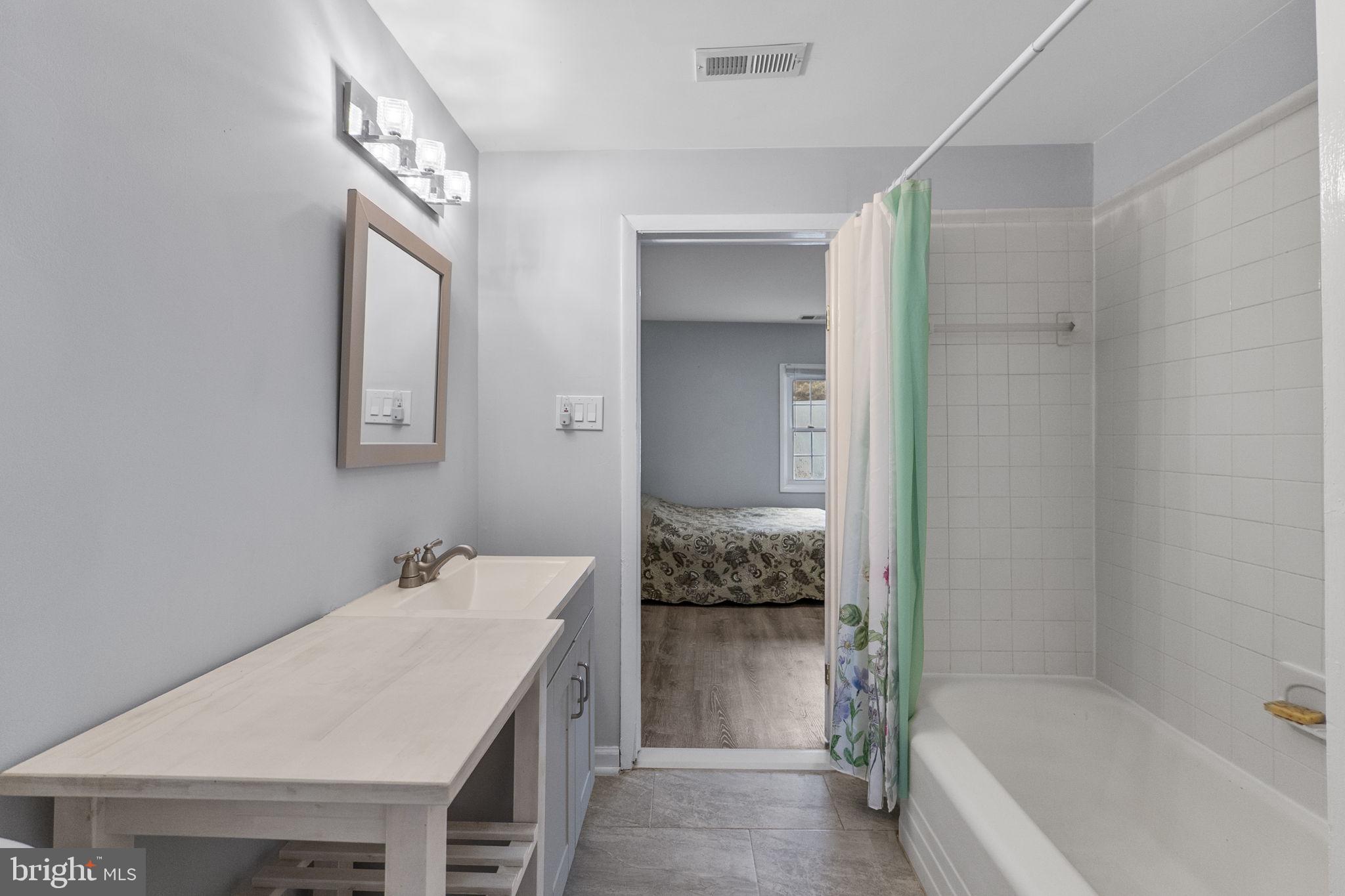 26001 Frederick Road Clarksburg, MD 20871 - Photo 24 of 46 a bathroom with a tub sink and mirror