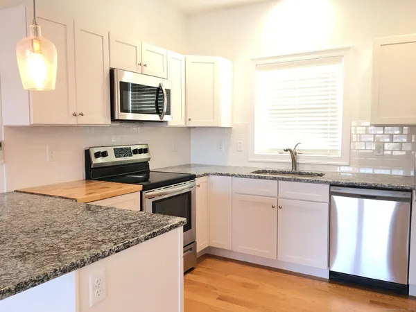 a kitchen with stainless steel appliances granite countertop a sink stove and microwave