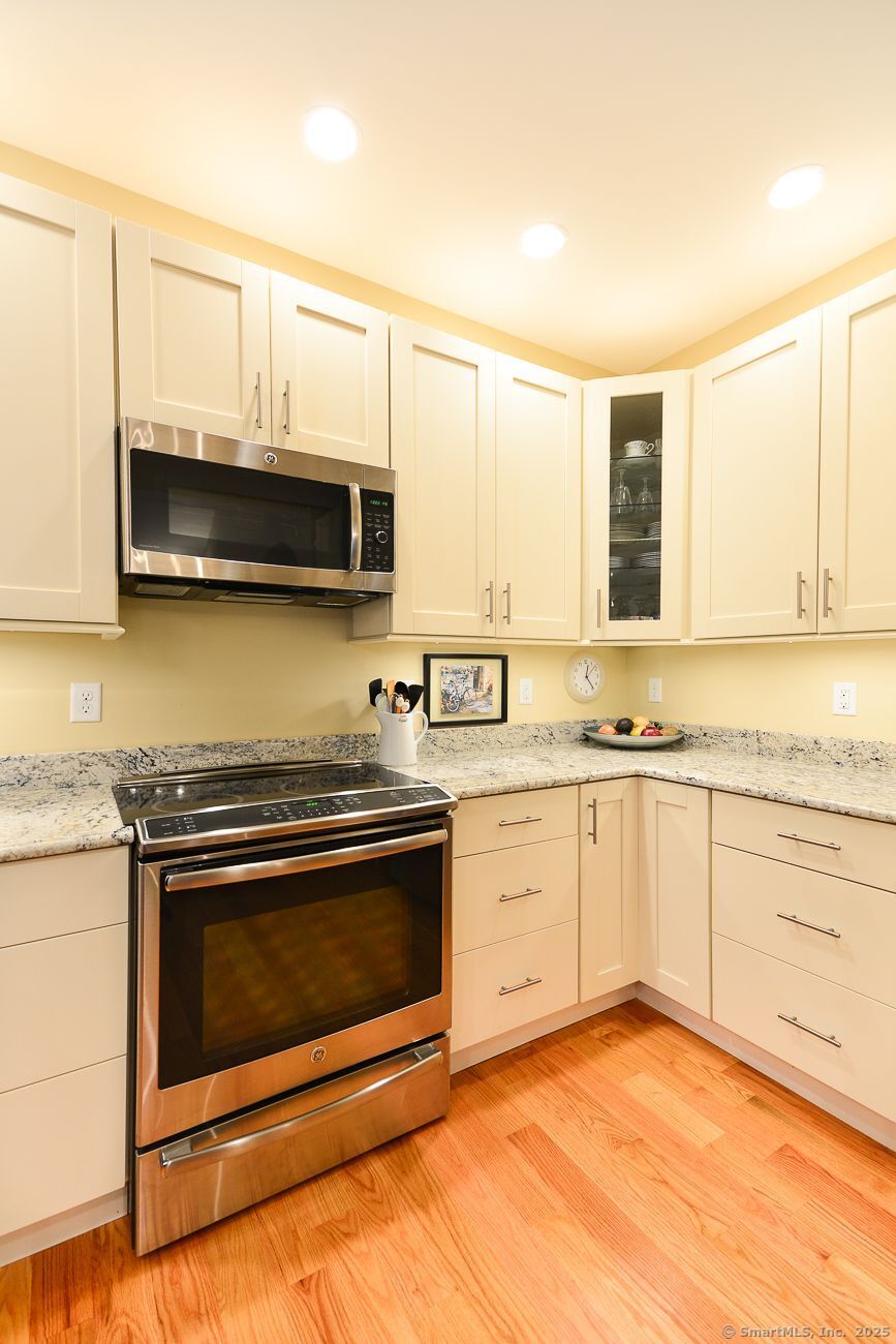 10 Fort Hill Road, Unit 6C Groton, CT 06340 - Photo 5 of 24 a kitchen with stainless steel appliances granite countertop a stove microwave and cabinets