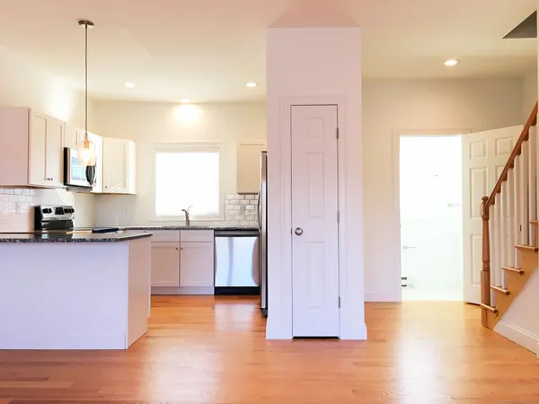 a kitchen with stainless steel appliances granite countertop a refrigerator a sink and a stove