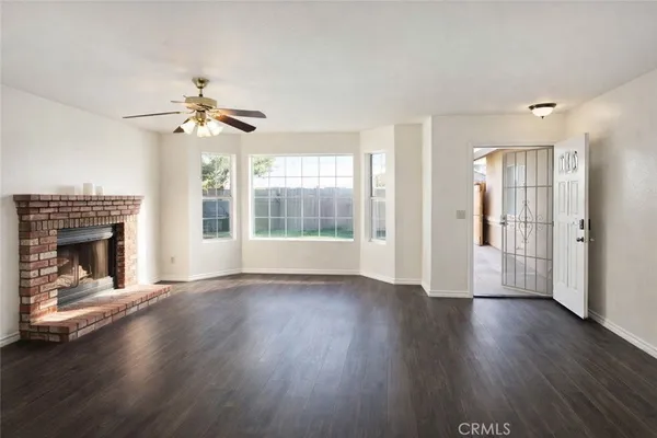 a view of empty room with wooden floor and fireplace