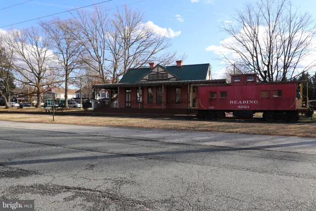 a front view of a building with streets and trees
