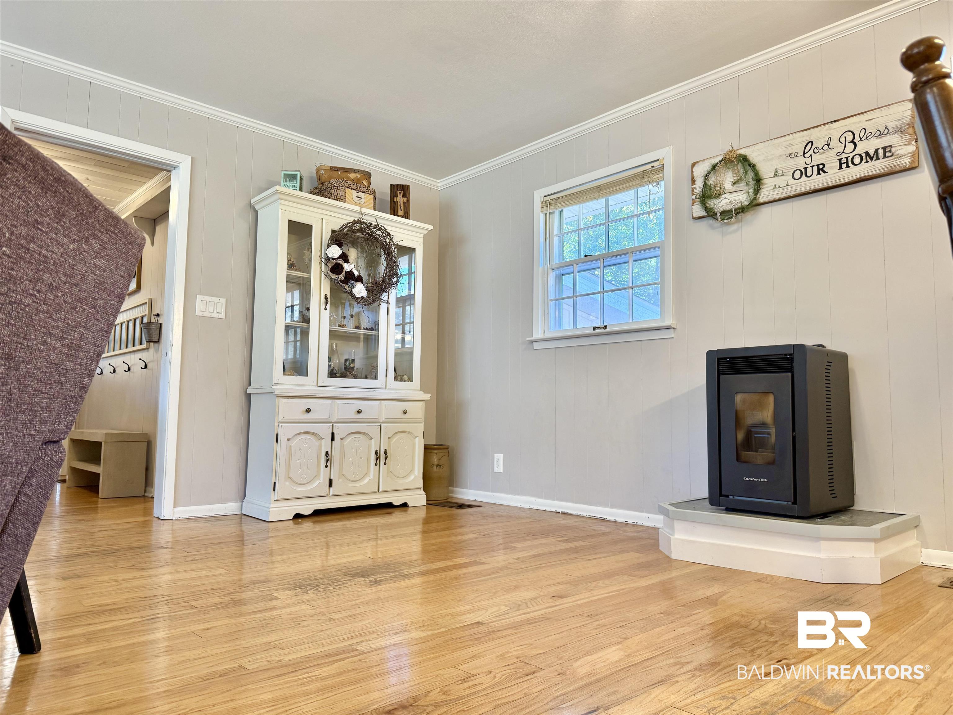 2785 Appleton Road Brewton, AL 36426 - Photo 6 of 28 Unfurnished dining area featuring a wood stove, ornamental molding, light wood-style flooring, and wood walls
