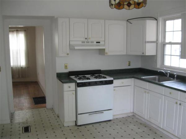 45 Algonquin Street Boston, MA 02124 - Photo 5 of 10 a kitchen with granite countertop white cabinets and white appliances