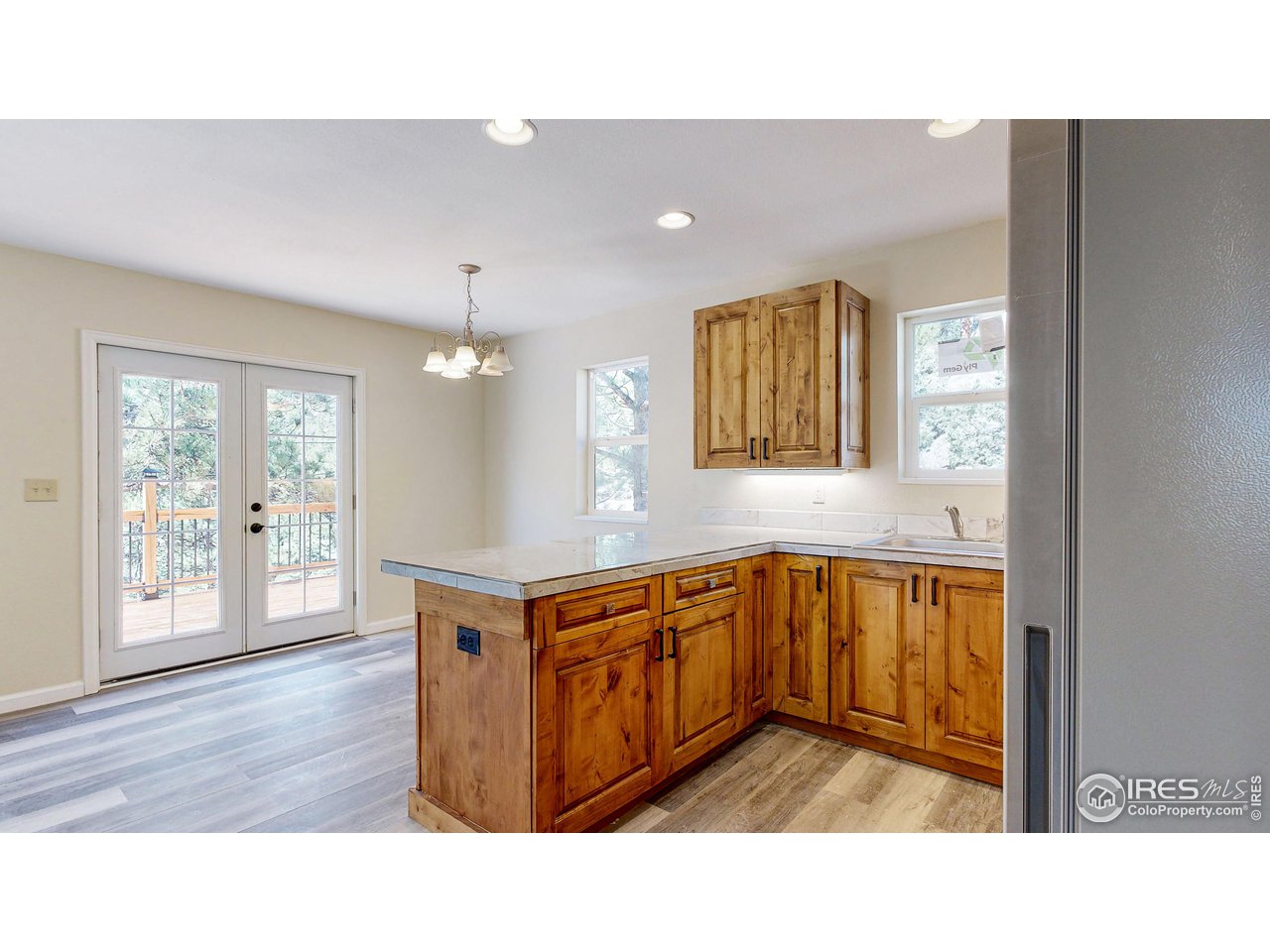 80 Hot Spur Lane Drake, CO 80515 - Photo 5 of 40 a kitchen with stainless steel appliances granite countertop a refrigerator a sink dishwasher and wooden cabinets with wooden floor