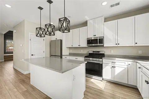 a kitchen with stainless steel appliances granite countertop a stove a sink and a refrigerator