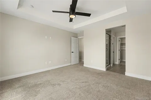 an empty room with a ceiling fan and carpet