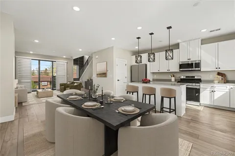 a kitchen with stainless steel appliances kitchen island granite countertop a stove a sink a dining table and chairs