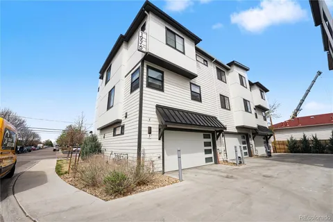 a view of a white building among the street with palm trees