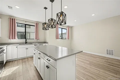 a kitchen with white cabinets and sink