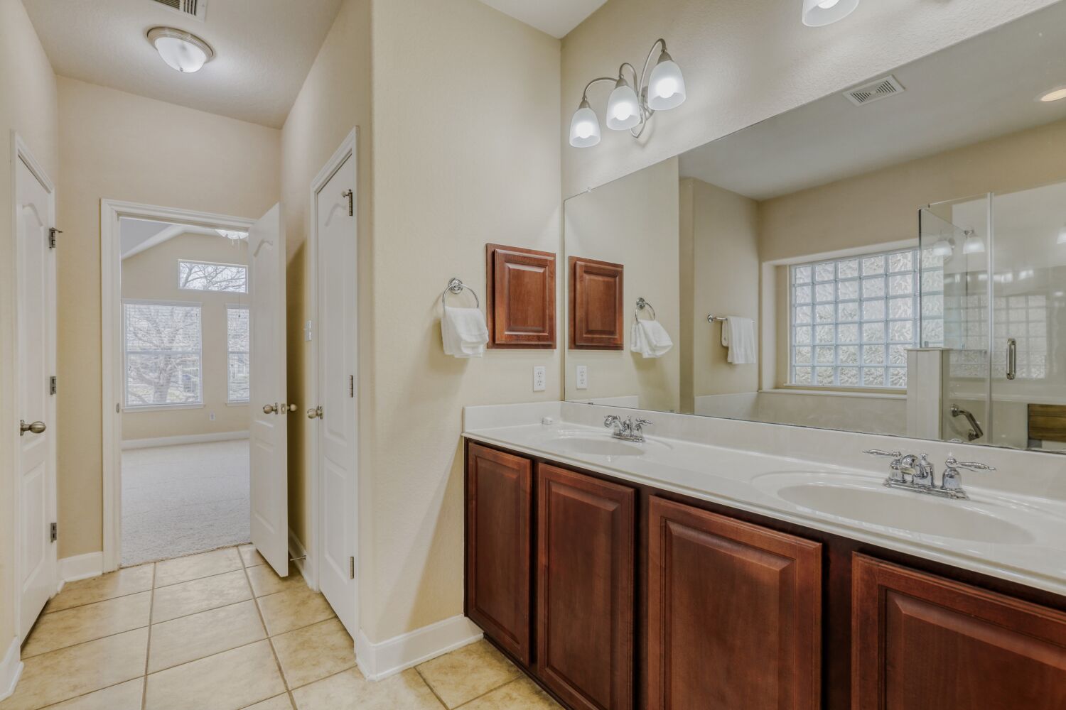 24 Stone Terrace Drive Austin, TX 78734 - Photo 11 of 31 Primary Bathroom with double vanity, a stall shower, light tile patterned flooring, and plenty of natural light