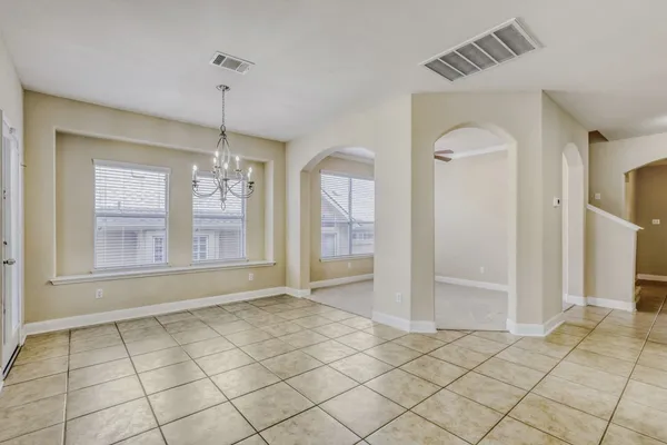an empty room with windows and fireplace