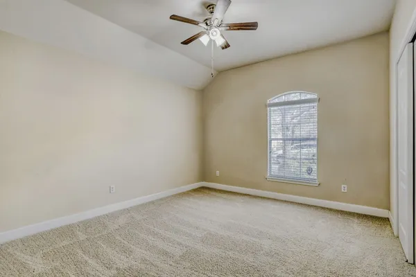 an empty room with windows and fan